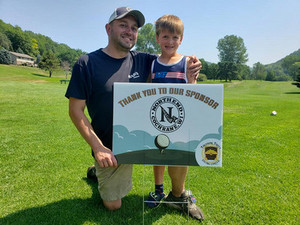 Man and boy holding Treasure Trove Giving Circle Thank You to Our Sponsors yard sign
