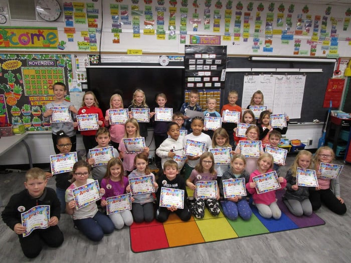 Group of 2nd graders holding reading certificates