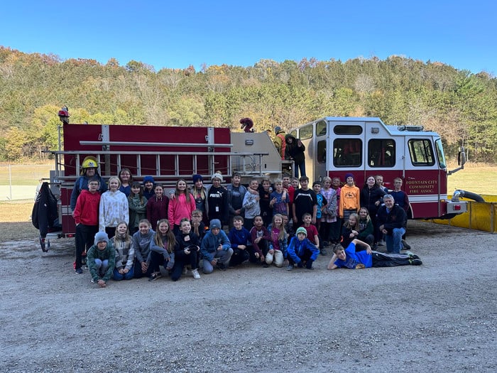 Fifth graders standing outside a fire engine